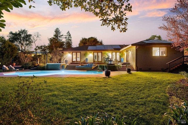 back of property with crawl space, a yard, solar panels, an outdoor pool, and french doors