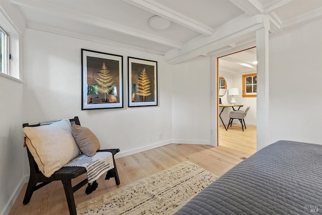 sitting room with beamed ceiling, baseboards, and wood finished floors