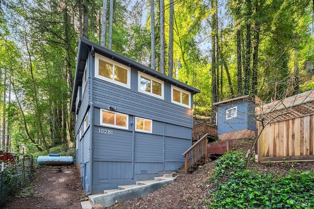 back of house with crawl space and stairs