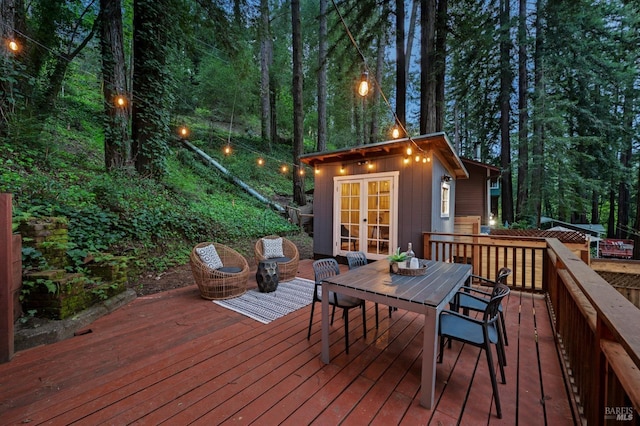 wooden terrace featuring outdoor dining space and french doors