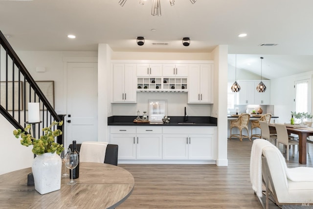 kitchen featuring light wood-style floors, visible vents, white cabinetry, and dark countertops