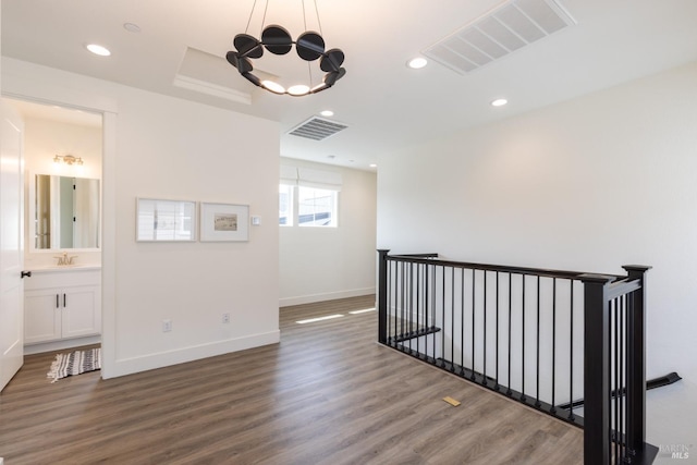 interior space featuring visible vents, recessed lighting, an upstairs landing, and wood finished floors