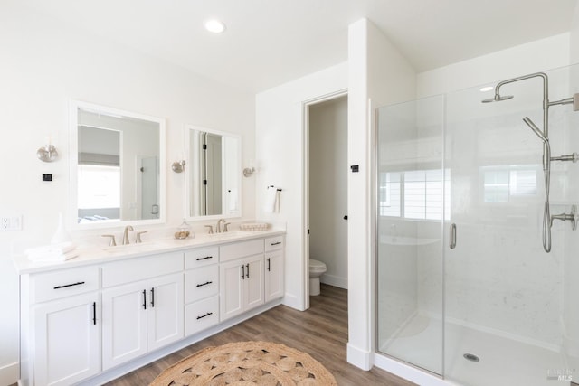 full bath with a shower stall, wood finished floors, a sink, and toilet