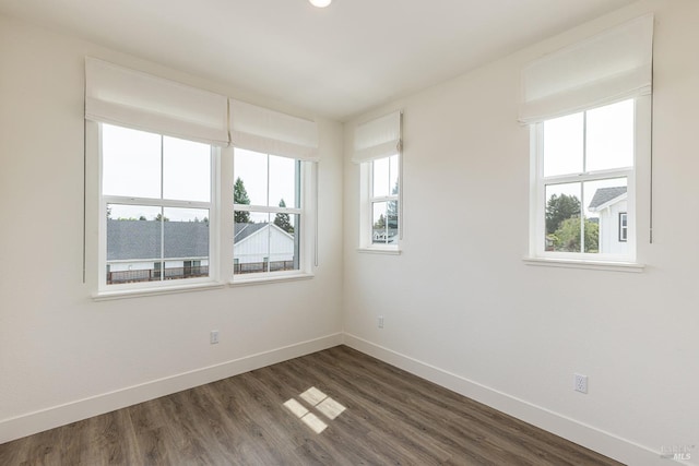 unfurnished room featuring dark wood-type flooring and baseboards