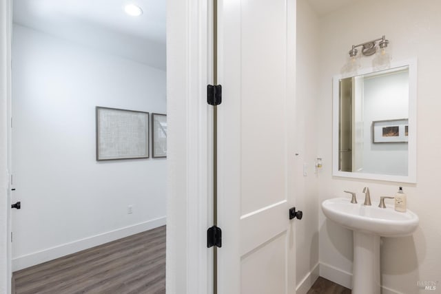 bathroom with baseboards and wood finished floors