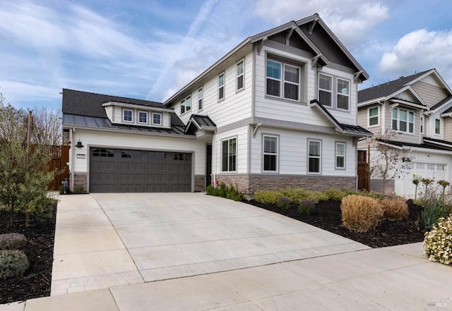 craftsman-style home with stone siding, metal roof, fence, concrete driveway, and a standing seam roof