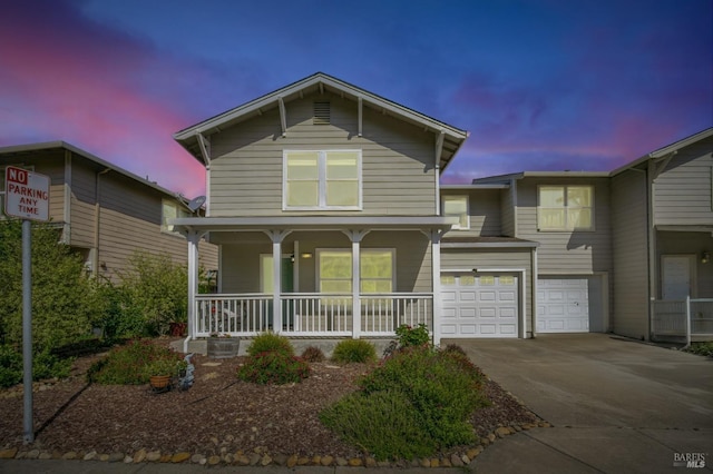 view of front of house featuring a garage, driveway, and covered porch