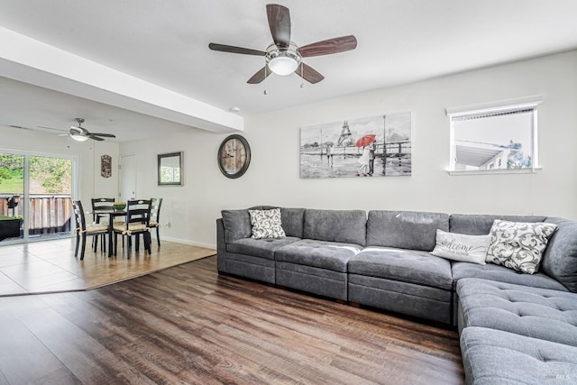 living area featuring baseboards, wood finished floors, and ceiling fan