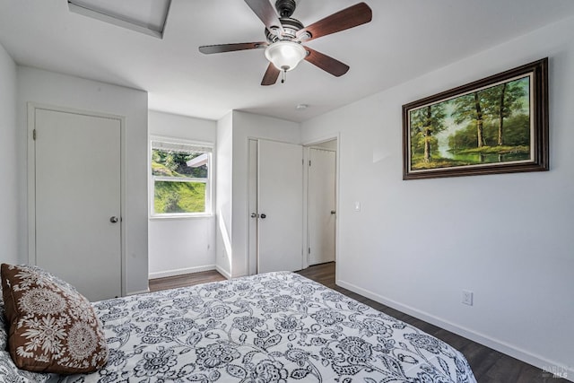 bedroom featuring baseboards, a ceiling fan, attic access, and dark wood finished floors