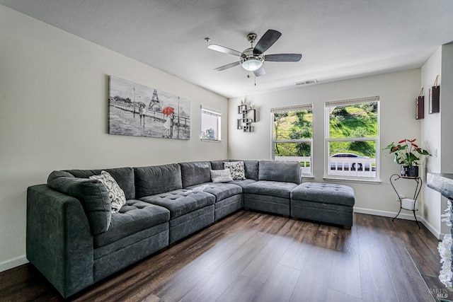 living room with visible vents, baseboards, dark wood-style flooring, a ceiling fan, and a textured ceiling