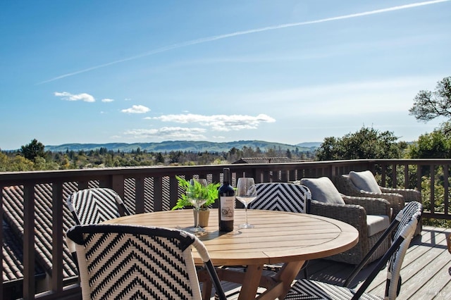 wooden deck featuring a mountain view and outdoor dining area