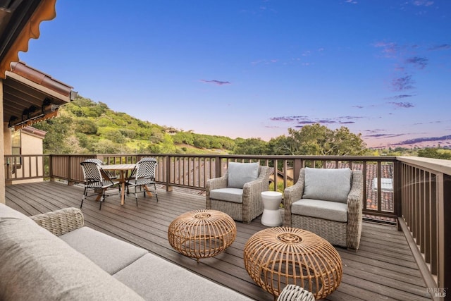 deck at dusk featuring an outdoor hangout area