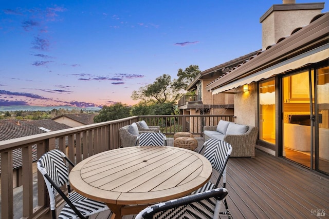 deck at dusk with outdoor dining area