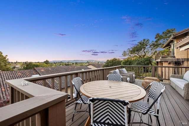 deck at dusk featuring outdoor dining space