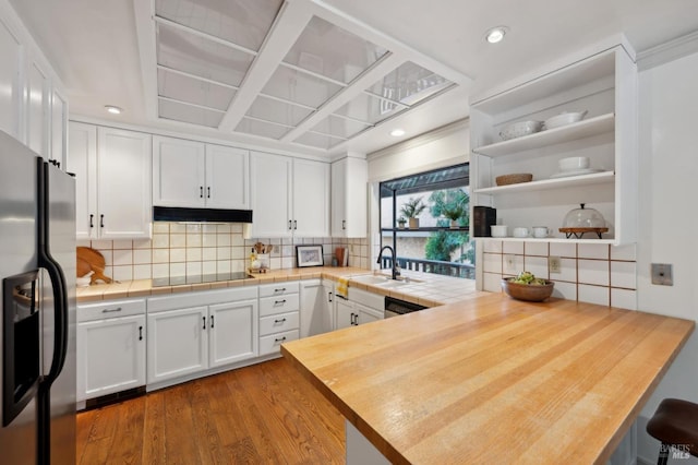kitchen featuring white cabinets, stainless steel refrigerator with ice dispenser, black electric cooktop, a sink, and a peninsula