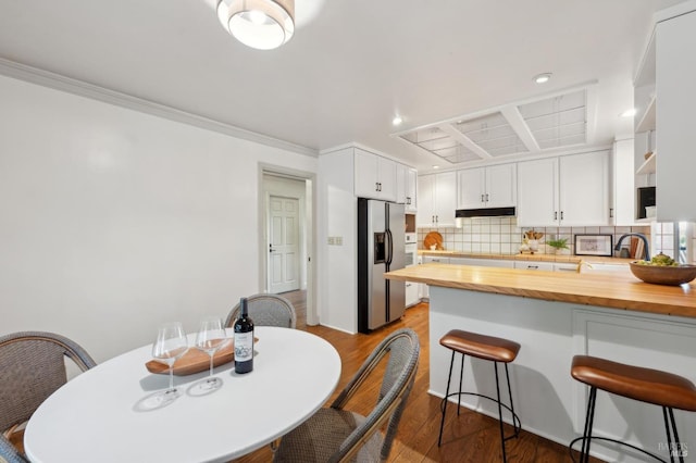dining area with dark wood-type flooring, crown molding, and recessed lighting
