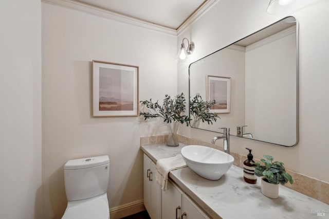 half bathroom with ornamental molding, toilet, and vanity