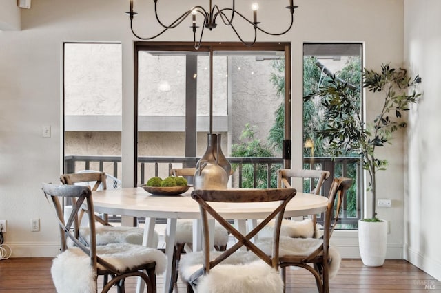 dining space with a chandelier, hardwood / wood-style flooring, baseboards, and a healthy amount of sunlight