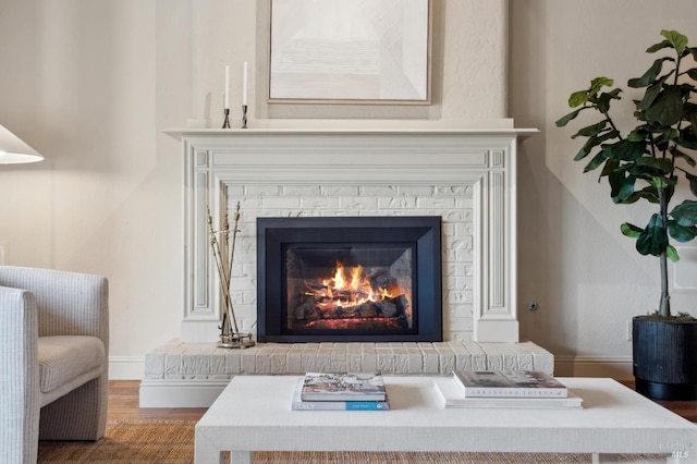 room details with a brick fireplace, wood finished floors, and baseboards