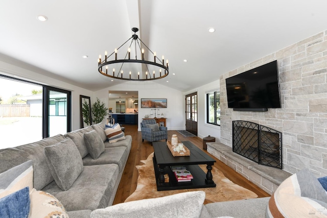 living area with wood finished floors, a fireplace, lofted ceiling, a chandelier, and recessed lighting