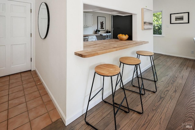 19 Savannah Ave, San Anselmo, CA 94960 - kitchen featuring a kitchen bar, wood finished floors, wood counters, baseboards, and backsplash