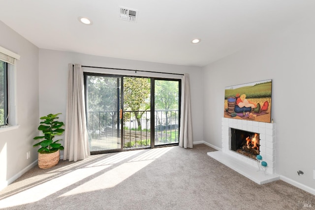 unfurnished living room featuring carpet flooring, a fireplace, visible vents, and recessed lighting