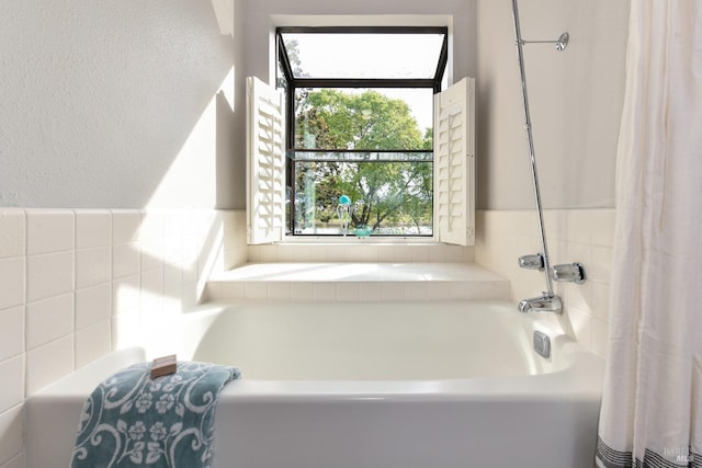 full bath featuring a bath, plenty of natural light, and a shower with curtain