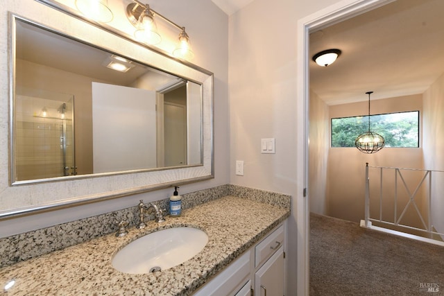 bathroom with a notable chandelier and vanity
