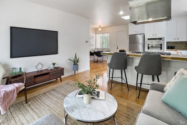 living area featuring light wood finished floors and baseboards