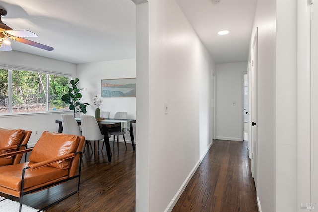 hallway featuring recessed lighting, dark wood-type flooring, and baseboards