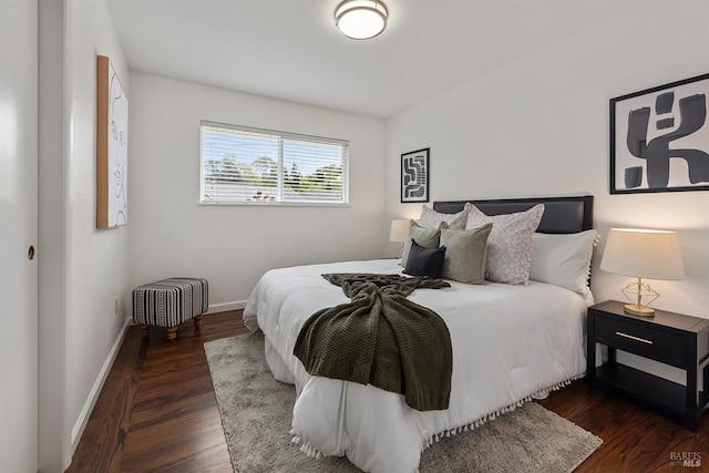 bedroom with baseboards and dark wood finished floors