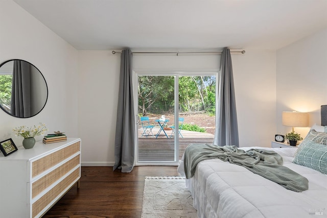 bedroom featuring access to exterior, baseboards, and wood finished floors