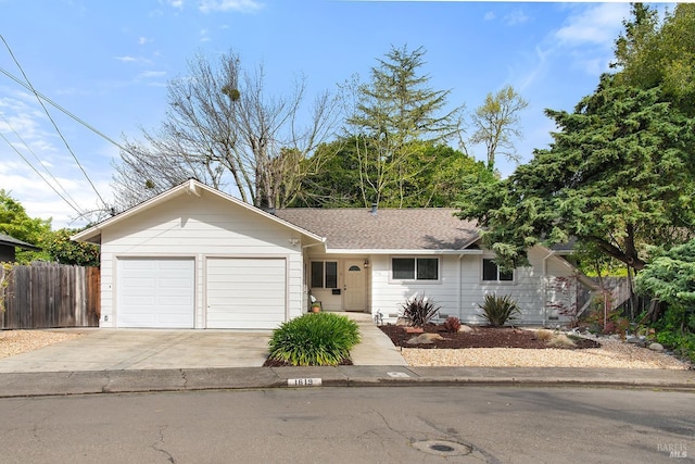ranch-style house with an attached garage, concrete driveway, and fence