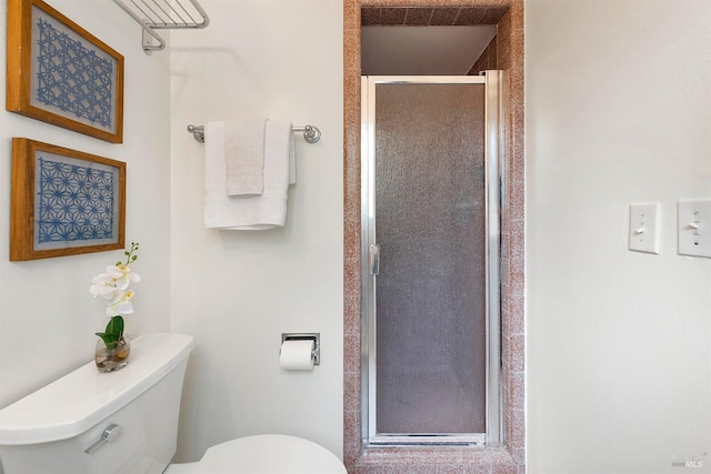 bathroom featuring a shower stall and toilet