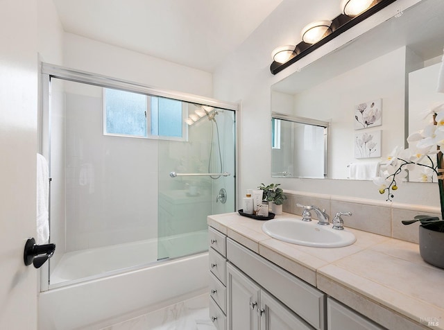 full bath featuring marble finish floor, enclosed tub / shower combo, and vanity