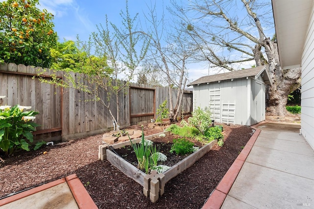view of yard with an outbuilding, a fenced backyard, a vegetable garden, and a storage unit