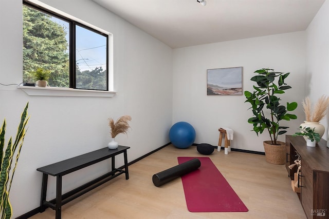 exercise room featuring baseboards and wood finished floors