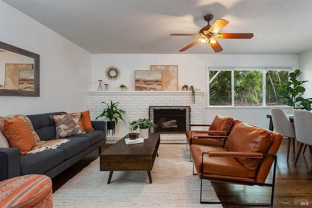living room featuring a ceiling fan, wood finished floors, and a fireplace