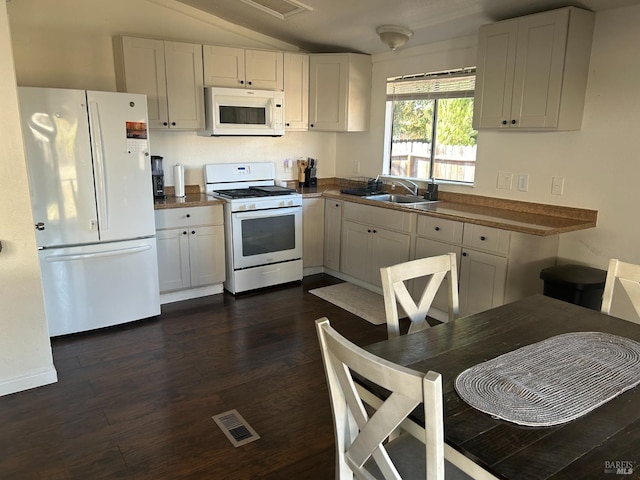 336 Hamilton Dr, Fairfield, CA 94533 - kitchen featuring white appliances, vaulted ceiling, a sink, white cabinetry, and dark wood finished floors