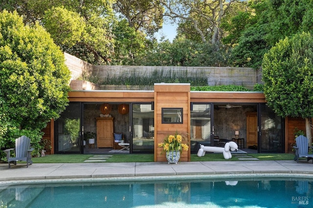 back of house with an outdoor pool and a patio area