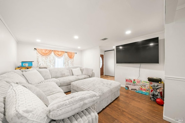 living area featuring crown molding, wood finished floors, visible vents, and recessed lighting
