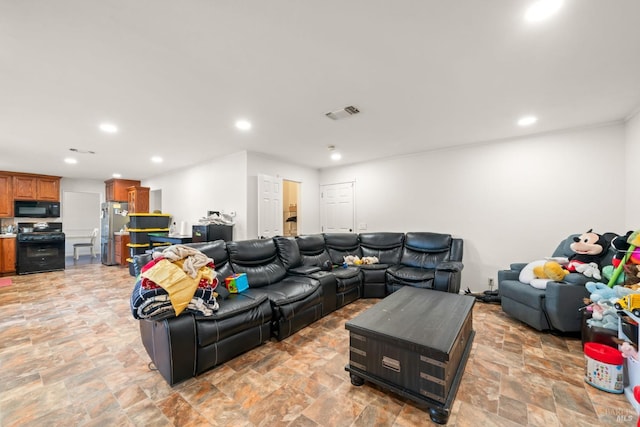 living area featuring recessed lighting, stone finish floor, and visible vents