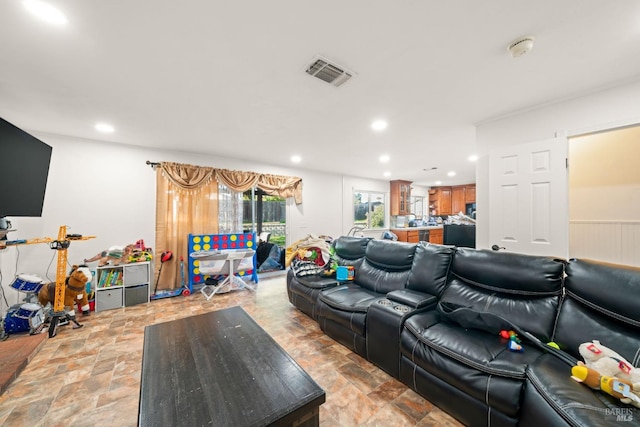 living room featuring stone finish floor, visible vents, and recessed lighting