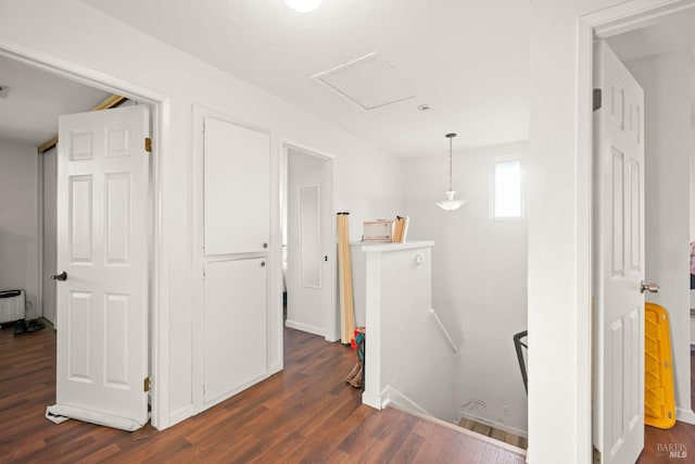 corridor featuring dark wood finished floors and an upstairs landing