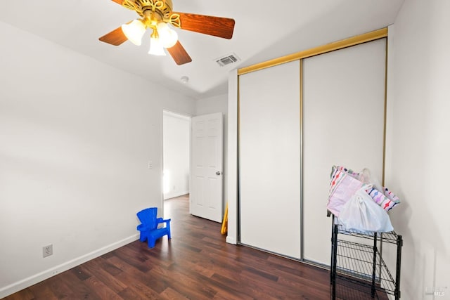 unfurnished bedroom featuring a closet, baseboards, visible vents, ceiling fan, and wood finished floors