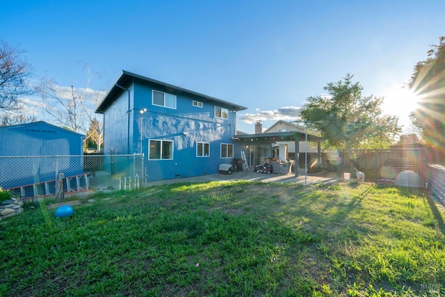 back of house featuring a yard, a fenced backyard, stucco siding, and a patio area
