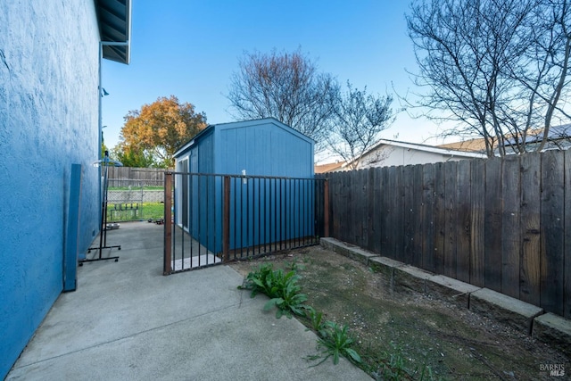 view of patio / terrace featuring a fenced backyard, an outdoor structure, and a storage unit