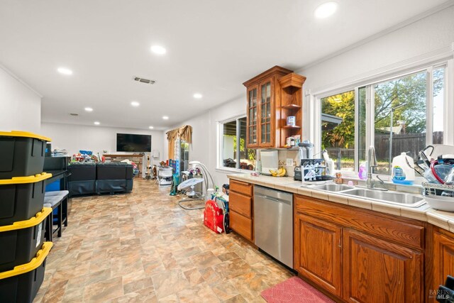 kitchen with open shelves, dishwasher, a sink, brown cabinetry, and tile countertops