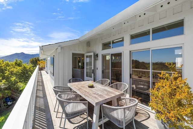 exterior space featuring a mountain view, outdoor dining area, and a balcony