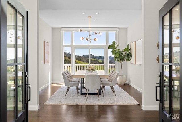 dining room featuring baseboards, an inviting chandelier, and dark wood finished floors